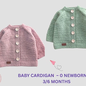 Könnte beinhalten: Zwei Baby-Strickjacken, eine rosa und eine grüne, werden gezeigt. Jede hat eine Knopfleiste und ein strukturiertes Strickmuster. Die Strickjacken sind für Neugeborene bis 3/6 Monate geeignet. Ein herzförmiges Logo und Text sind ebenfalls sichtbar.