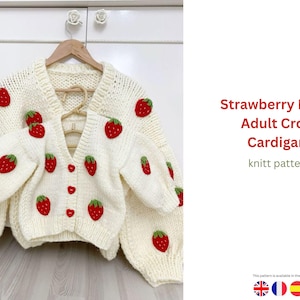 May include: Cream-colored, knitted cardigan with red strawberry appliqués and green leaves. The cropped sweater has a V-neck and button closure. The image also shows a smaller matching cardigan. Text on the right reads "Strawberry Motif Adult Crop Cardigan knitt pattern."