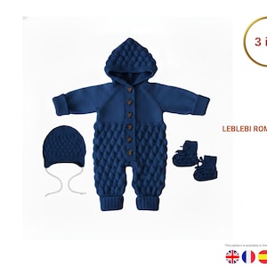 May include: A navy blue knitted baby romper set, including a hooded jumpsuit, hat with ties, and booties. The romper features a textured diamond pattern and wooden buttons. The set is labeled "LEBLEBI ROMPER SET" and is designed for infants.