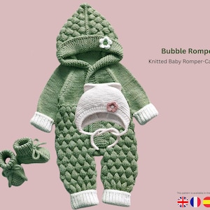 May include: A green knitted baby romper set, featuring a hooded romper, cap, and booties. The set includes a hooded romper, a white cap with a flower, and matching booties. The romper has a textured bubble pattern and white trim. The text "Bubble Romper Set" is visible.