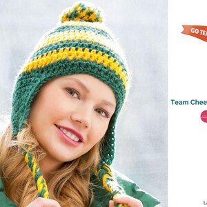 May include: A green and yellow striped crochet hat with earflaps and a pom pom on top. The hat has a "Go Team" flag attached to it.