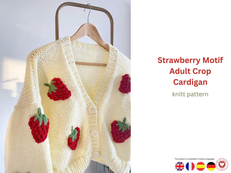Puede incluir: C&aacute;rdigan color crema con botones, aplicaciones de fresas rojas y hojas verdes. La prenda de punto est&aacute; colgada en una percha de madera. El texto de la derecha dice "Strawberry Motif Adult Crop Cardigan knitt pattern."