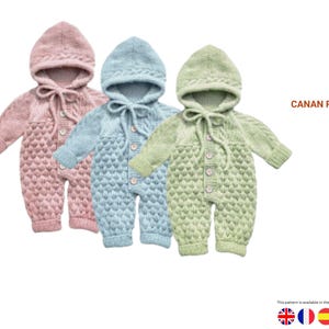 以下が含まれることがあります： ピンク、ブルー、グリーンの3色のニットベビーロンパース。それぞれフードとボタン留めが付いています。 ロンパースはテクスチャードステッチパターンとフードにネクタイが付いています。 画像には「CANAN ROMPER」という文字が表示されています。