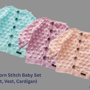 Puede incluir: Tres cárdigans para bebés en colores pastel: azul claro, rosa y melocotón. Cada cárdigan presenta un diseño de punto de palomitas, cierres de botones y pequeñas etiquetas. El texto "Popcorn Stitch Baby Set (Hat, Vest, Cardigan)" es visible.