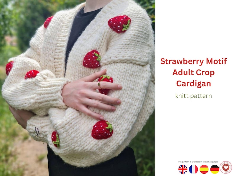 Puede incluir: C&aacute;rdigan de punto grueso color crema adornado con aplicaciones de fresas rojas. El su&eacute;ter corto tiene cuello en V y mangas largas. El texto en la imagen dice "Strawberry Motif Adult Crop Cardigan knitt pattern."