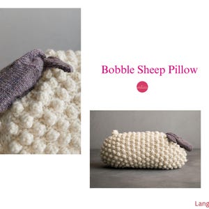May include: A cream-coloured bobble sheep pillow with a grey knitted head and ears. The pillow has a textured surface with bobble detailing. The text "Bobble Sheep Pillow" is displayed in pink.