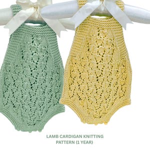 Puede incluir: Dos peleles de bebé tejidos, uno verde pálido y otro amarillo, cuelgan de perchas blancas con lazos color crema. Los peleles presentan un detallado calado. El texto en la parte inferior dice "LAMB CARDIGAN KNITTING PATTERN (1 YEAR)".