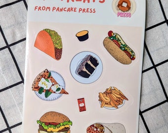 May include: A sheet of stickers featuring illustrations of various foods, including a taco, slice of pizza, burger, hot dog, fries, cake, burrito, and a small container of sauce. The text "LIL TREATS FROM PANCAKE PRESS" is printed at the top.