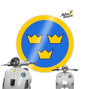 May include: A circular sticker featuring a blue field with three gold crowns, framed by a yellow border. Two white scooters are shown, each displaying a similar sticker. The Mia Buzz logo is visible in the top right.