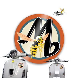 May include: A white scooter with a round sticker featuring a cartoon wasp wearing a helmet with Italian flag colours. The sticker is set against a circular background with the letter "M" and the words "Mia Buzz".