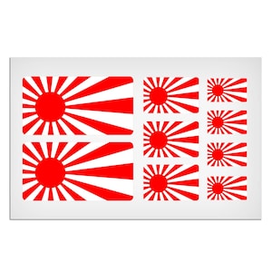Peut inclure: Une feuille d'autocollants rouges et blancs représentant le drapeau japonais du soleil levant en différentes tailles.