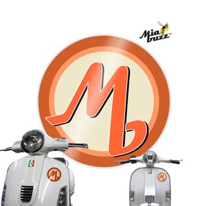 May include: White scooter with an orange logo featuring a large orange letter "M". The logo is in the centre of the image, with the scooter in the foreground. The logo also has the text "Mia Buzz" and a cartoon bee.