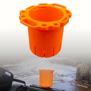 Peut inclure: Un porte-gobelet cylindrique orange vif doté d'un rebord large et cranté avec plusieurs fentes circulaires et rectangulaires. Le porte-gobelet présente des fentes verticales sur les côtés et un logo moulé sur la surface extérieure supérieure.