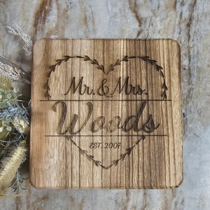 May include: A rustic wooden sign with a heart-shaped design and the text "Mr. & Mrs. Woods Est. 2007".