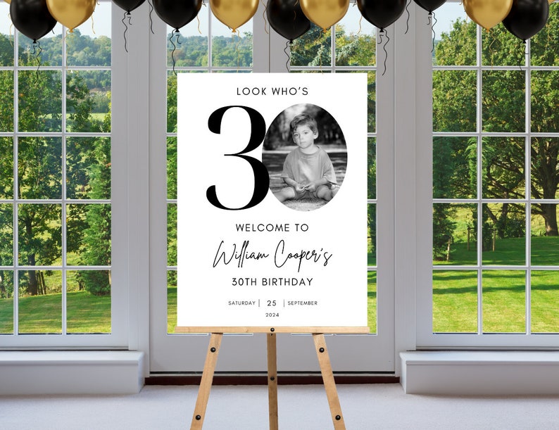 May include: A black and white welcome sign with the text "Look Who's 30" and a photo of a young boy. The sign also includes the text "Welcome to William Cooper's 30th Birthday" and the date "Saturday 25 September 2024".