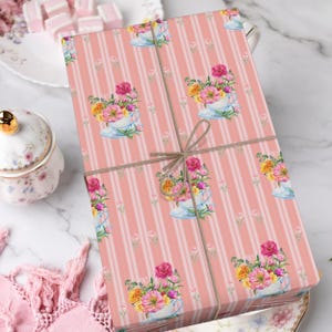 May include: Pink and white striped wrapping paper with a floral pattern of pink, yellow, and white flowers in teacups. The paper is tied with a brown twine bow.