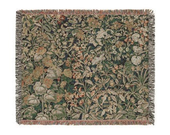 May include: A woven tapestry throw blanket with a floral pattern in shades of green, brown, and orange. The blanket has a fringed border.