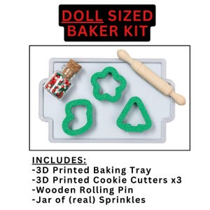 May include: A doll-sized baking kit with a 3D printed baking tray, three cookie cutters, a wooden rolling pin, and a jar of sprinkles. The cookie cutters are shaped like a star, a tree, and a boot. The tray is gray and the cookie cutters are green. The rolling pin is wooden and the sprinkles are red, green, and white.