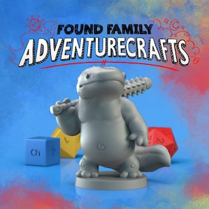 May include: A gray axolotl figurine holding a spiked club, with the text "FOUND FAMILY ADVENTURECRAFTS" above. A blue, yellow, and red die are in the background. The axolotl is on a round base.