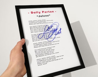 Könnte beinhalten: Ein gerahmter Druck mit dem Liedtext von Jolene von Dolly Parton, gedruckt in schwarzer Schrift auf weißem Hintergrund. Der Druck enthält eine blaue Tintensignatur in der Mitte des Textes, alles in einem dünnen schwarzen Rahmen.
