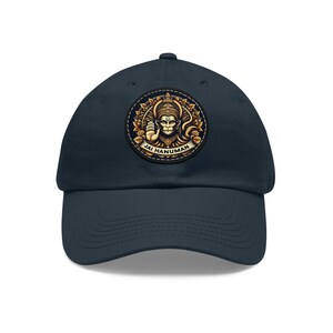May include: A navy blue baseball cap with a gold and black embroidered patch featuring a Hindu deity, Hanuman, with the text "Jai Hanuman".