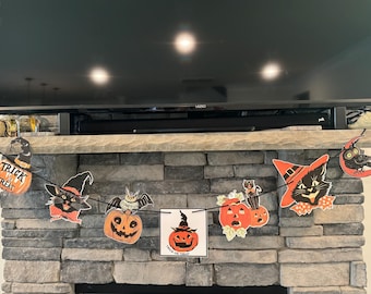 May include: A Halloween banner with black cats, pumpkins, and bats. The banner says "Trick or Treat" on one of the pumpkins.