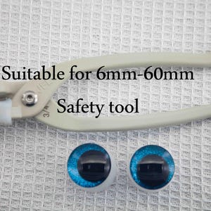 May include: A white plastic safety tool for setting doll eyes. The tool is labeled "Suitable for 6mm-60mm". Two blue plastic doll eyes are also shown.