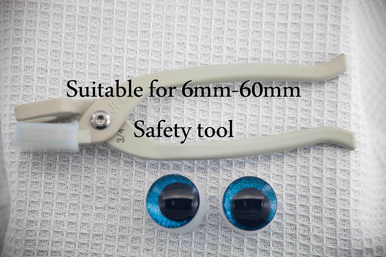 May include: A white plastic safety tool for setting doll eyes. The tool is labeled "Suitable for 6mm-60mm". Two blue plastic doll eyes are also shown.