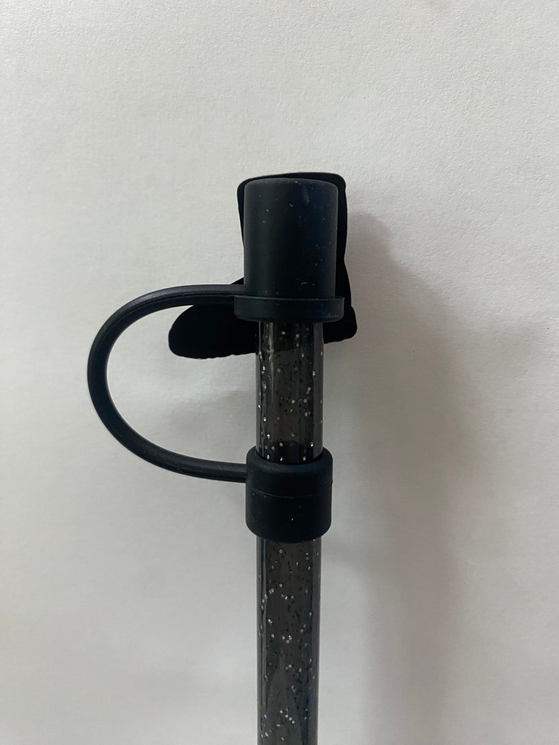 May include: Black silicone straw with a black glitter design and a black silicone loop handle.