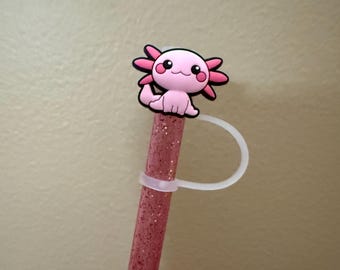 May include: Pink glitter straw with a pink axolotl charm attached to the top. The charm has a white loop for attaching to the straw.