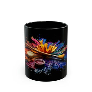 May include: Black coffee mug with a colorful paint splatter design and a paintbrush and paint pots.