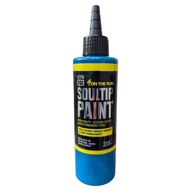 May include: A blue bottle of Soultip paint with a black label and yellow accents. The label reads "OTR 901 ON THE RUN SOULTIP PAINT HIGH QUALITY - ALCOHOL BASED SUPER PERMANENT PAINT HIGH GLOSSY/HIGHLY OPAQUE SUPER PERMANENT Designed for the ON THE RUN Soultip Permanent Markers 210".