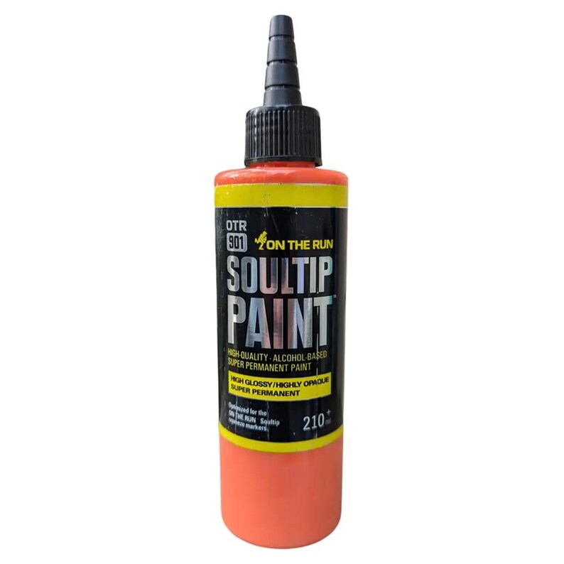 May include: A bottle of orange Soultip paint with a black cap and a yellow label. The label reads "OTR 901 ON THE RUN SOULTIP PAINT HIGH-QUALITY-ALCOHOL BASED SUPER PERMANENT PAINT HGH GLOSSY/HIGHLY OPAQUE SUPER PERMANENT 210".