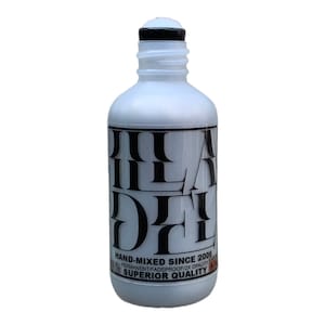 Pode incluir: Uma garrafa de plástico branca com uma tampa preta e um rótulo preto que diz "HAND-MIXED SINCE 2006" e "SUPERIOR QUALITY".