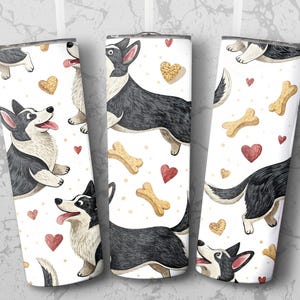 Op de afbeelding: Drie witte roestvrijstalen bekers met een herhaald patroon van zwart-witte corgi-honden, harten en hondenbotten. De corgi's staan in verschillende poses, met hun tongen uit. De harten en botten zijn goud en rood.