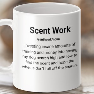May include: White ceramic mug with a black graphic that reads "Scent Work /sent/work/noun Investing insane amounts of training and money into having my dog search high and low to find the scent and hope the wheels don't fall off the search."