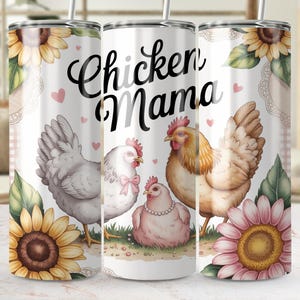 Può includere: Un bicchiere bianco con la scritta "Chicken Mama" e illustrazioni di galline, girasoli e cuori. Il design comprende una gallina grigia, una gallina bianca con un fiocco rosa e una gallina marrone. Il bicchiere ha una cannuccia.