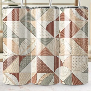 May include: Three stainless steel tumblers with geometric patterns in shades of beige, brown, and gray. The design features triangles, semi-circles, and dotted patterns. Each tumbler has a silver straw.
