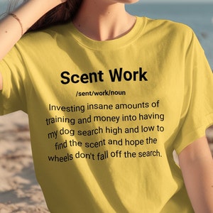 May include: A yellow t-shirt with a definition of "Scent Work" printed on it. The definition reads: "Investing insane amounts of training and money into having my dog search high and low to find the scent and hope the wheels don't fall off the search."