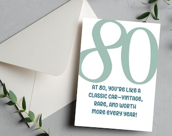 May include: A white card with a teal blue number 80. The text reads "At 80, you're like a classic car - vintage, rare, and worth more every year!"