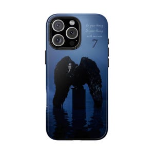 May include: A dark blue phone case featuring a person with black angel wings. The background is a dark blue with the text "Do your thang, Do your thang with me now 7". The phone case has a triple camera system.