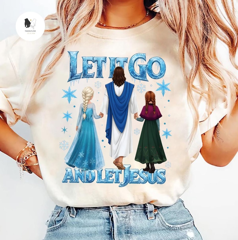 May include: Cream-colored t-shirt featuring the text "LET IT GO AND LET JESUS" in blue. The graphic depicts Jesus holding hands with two cartoon characters in blue and green dresses, with snowflakes.