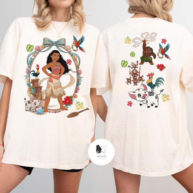 以下が含まれることがあります： ポリネシアの女性と熱帯の要素が描かれた、クリーム色のTシャツ。背中には追加のキャラクターと花の模様が描かれています。半袖でゆったりとしたフィット感があり、カジュアルウェアに適しています。