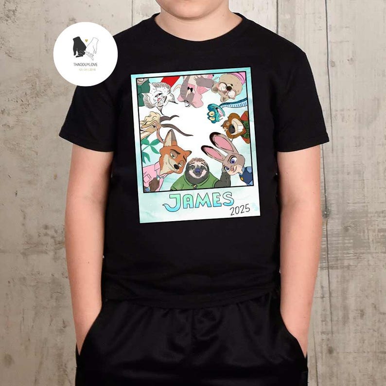 以下が含まれることがあります： 黒いTシャツ。ポラロイド風のグラフィックで、漫画のキャラクターが描かれています。グラフィックには「JAMES」という名前と「2025」という年号が含まれています。このTシャツは柔らかい素材でできており、普段使いに適しています。