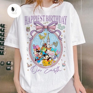 May include: White t-shirt with a colorful graphic featuring Disney characters and the text "Happiest Birthday On Earth." The design includes Mickey Mouse, Minnie Mouse, Donald Duck, and other characters, with a castle and fireworks.