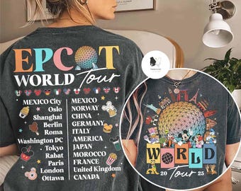 May include: A black t-shirt with a colourful graphic of the Epcot World Tour. The graphic features a globe with a rainbow design and the text "World Tour 20 25". The shirt also has a list of cities and countries on the back.