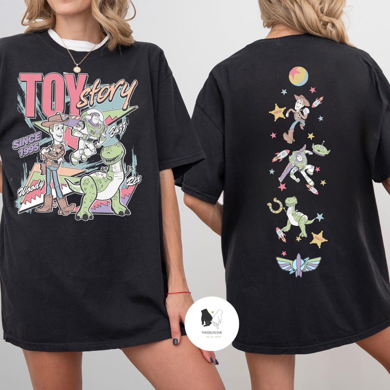 May include: Black t-shirt featuring a colorful graphic of Toy Story characters, including Woody, Buzz Lightyear, and Rex, with the text "TOY STORY" and "SINCE 1995". The back of the shirt displays additional character illustrations.