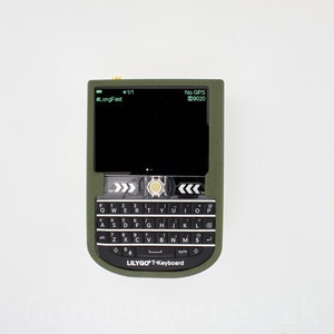 K&ouml;nnte beinhalten: Eine gr&uuml;n-schwarze LilyGO T-Tastatur mit einer QWERTY-Tastatur und einem Bildschirm, auf dem "#LongFest" und "No GPS 00:20" steht.