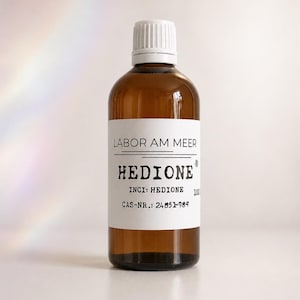 Könnte beinhalten: Eine Braunglasflasche mit weißem Schraubverschluss und weißem Etikett. Das Etikett trägt den Text LABOR AM MEER, HEDIONE, INCI: HEDIONE und CAS-NR.: 24851-98-7. Die Flasche enthält eine flüssige Substanz und ist in aufrechter Position dargestellt.