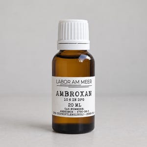 Puede incluir: Un frasco pequeño de vidrio ámbar con tapa de rosca blanca y etiqueta blanca. La etiqueta dice LABOR AM MEER, AMBROXAN, 10% IN DPG, 20 ML, CAS-NUMMERN: AMBERMOR - 6790-58-5, DPG (DIPROPYLENGLYKOL) - 25265-71-8.